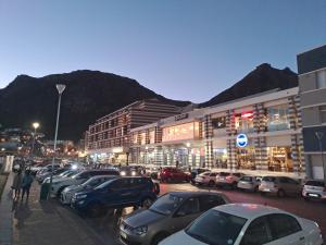 ケープタウンにあるMadeira Houseの建物の前にたくさんの車が駐車されている駐車場