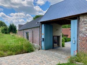 a brick building with a blue door on the side at Nachtegael Zomerhuis, idyllische woning in de Vlaamse Ardennen in Kluisbergen