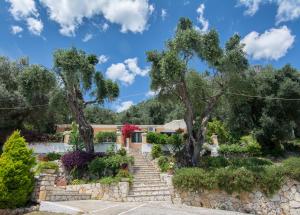 a garden with stairs and trees in front of a house at Eleni's Apartments in Barbati