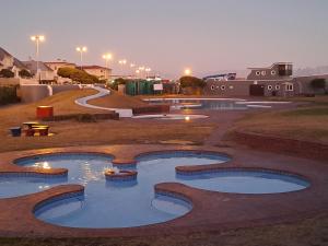 a couple of pools in a park at night at Madeira House in Cape Town