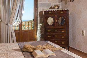 - une chambre avec un lit avec deux livres et une commode dans l'établissement Luxury Crete Villa Villa Melpomeni Private Pool Private Playground 5 BDR Rethymno, à Vederoi