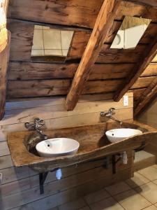 a bathroom with two sinks on a wooden wall at Gîte de groupe Arza Mendi in Jurvielle