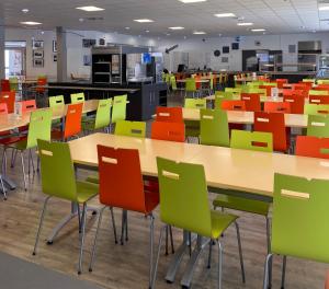 an empty classroom with tables and colorful chairs at Ethic étapes Val de Loire in Blois