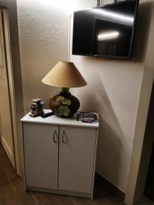 a lamp sitting on top of a cabinet with a table at Joli appartement au cœur du village in Orsières