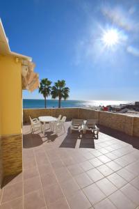 une terrasse avec une table et des chaises et la plage dans l'établissement CARIHUELA 1ª LÍNEA DE PLAYA, à Torremolinos