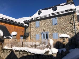 een stenen huis met sneeuw op het dak bij Gîte de groupe Arza Mendi in Jurvielle