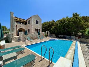 a villa with a swimming pool and a house at Villa Afrati Sea Views Pool AC in Plaka
