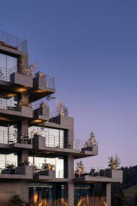 un edificio alto con balcones y luces. en HAY boutique hotel & SPA by Edem Family en Bukovel