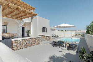 un patio con tavolo, sedie e piscina di Escape View Villa with private pool by Caldera Houses a Éxo Goniá