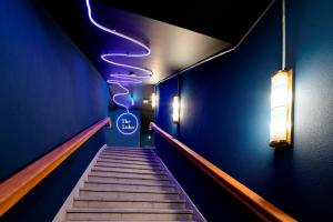 a hallway with a staircase with blue walls and lights at The Lubo - self check-in in Lucerne