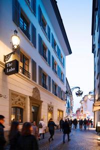 a group of people walking down a street near a building at The Lubo - self check-in in Lucerne