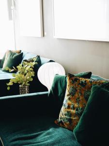 a green couch with pillows and a plant on it at Clarion Hotel Arlanda Airport Terminal in Arlanda