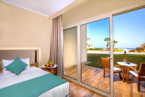 a bedroom with a bed and a balcony with a view of the ocean at Zen Resort Sahl Hasheesh by TBH Hotels in Hurghada