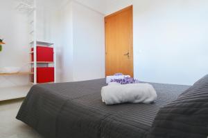 una camera da letto con un letto con un cuscino bianco di La casa di Lillo a Marina di Ragusa
