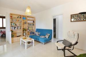 un soggiorno con divano blu e sedia di La casa di Lillo a Marina di Ragusa