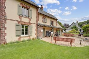 a house with a bench in the yard at Villa l'Hermitage Piscine Sauna Fitness Deauville in Bénerville-sur-Mer