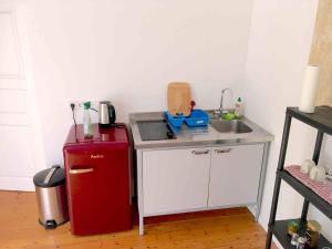 a small kitchen with a red refrigerator and a sink at Gartenhaus mit Sauna am Buckowsee, Märkische Schweiz in Buckow