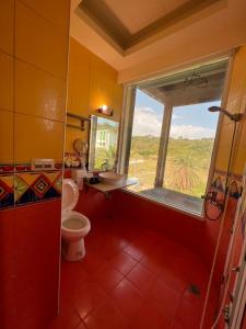 a bathroom with a window and a toilet and a sink at Ming Jun Homestay in Eluan