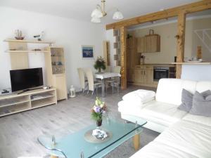 a living room with a white couch and a table at Ruegen_Fewo 37 in Zirkow