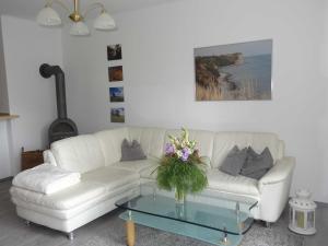 a living room with a white couch and a glass table at Ruegen_Fewo 37 in Zirkow