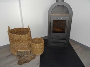 a fireplace with two baskets and a stove at Ruegen_Fewo 37 in Zirkow