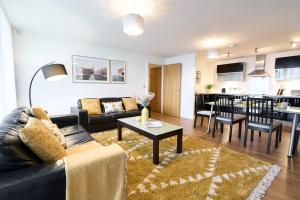 a living room with a couch and a table at ShortstayMK Vizion apartments, with free superfast wi-fi, parking, Sky sports and movies in Milton Keynes