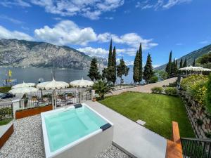 a house with a swimming pool and a garden at Hotel Oasi Beach in Malcesine