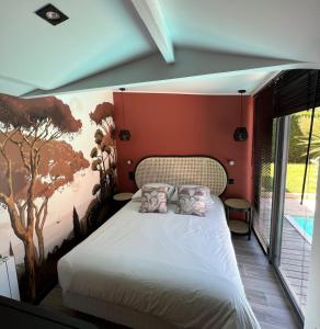 a bedroom with a bed with a painting on the wall at Villa l'Hermitage Piscine Sauna Fitness Deauville in Bénerville-sur-Mer +25 photos