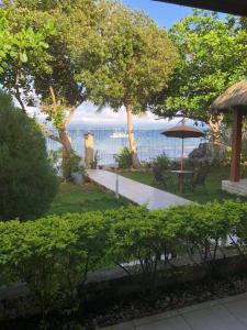 a view of the ocean from a garden with an umbrella at Ancelle Cristo Re in Moalboal