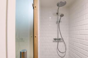 La salle de bains est pourvue d'une douche avec un pommeau de douche. dans l'établissement Lenderi Villa Luxury Apartments with Sauna, à Tallinn