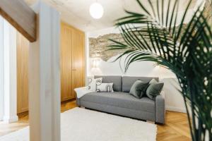 un salon avec un canapé et une plante dans l'établissement Lenderi Villa Luxury Apartments with Sauna, à Tallinn