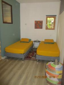 two beds with yellow covers in a room at La Pommeraie in Casteil