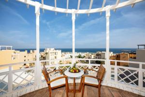 a balcony with a table and chairs and a view of the city at Zen Resort Sahl Hasheesh by TBH Hotels in Hurghada