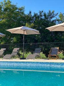 Champagne-et-Fontaine的住宿－Métairie des Gâcheries，游泳池旁的游泳池配有椅子和遮阳伞