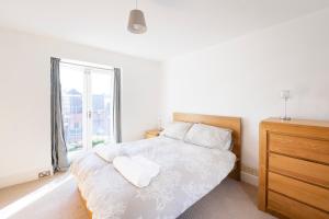 a bedroom with a white bed with a large window at Fabulous 2 bedroom cottage in fantastic Clifton - Simply Check In in Bristol