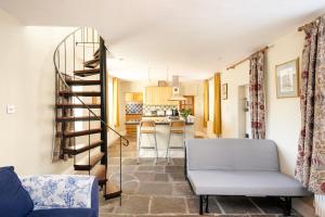 a living room with a spiral staircase and a kitchen at Fabulous 2 bedroom cottage in fantastic Clifton - Simply Check In in Bristol