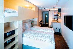 1 Schlafzimmer mit 2 Etagenbetten und einem TV in der Unterkunft The Lubo - self check-in in Luzern