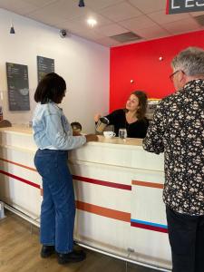 two people standing at a counter at a restaurant at Ethic étapes Val de Loire in Blois
