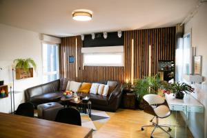 a living room with a couch and a table at L'Échappée Parisienne - Canal St-Denis in Aubervilliers