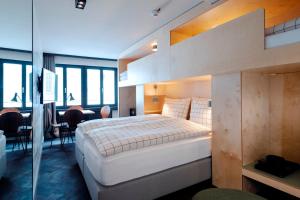 a bedroom with a large bed and a dining room at The Lubo - self check-in in Lucerne