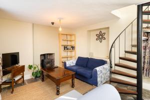a living room with a blue couch and a tv at Fabulous 2 bedroom cottage in fantastic Clifton - Simply Check In in Bristol