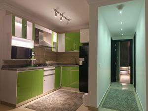 cocina con armarios verdes y nevera negra en Sheraton ocean 203 - Private apartments en El Cairo