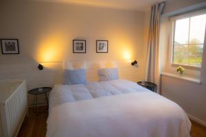 a bedroom with a white bed and a window at Vento in Westermarkelsdorf