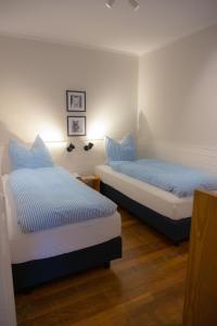 two beds in a room with blue pillows at Vento in Westermarkelsdorf