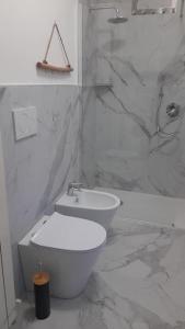 a white bathroom with a toilet and a sink at Casa Dea 3 in Seriate