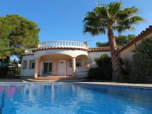 een huis met een palmboom en een zwembad bij Villa Mila in L'Ametlla de Mar