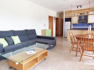 een woonkamer met een blauwe bank en een tafel bij Villa Mila in L'Ametlla de Mar