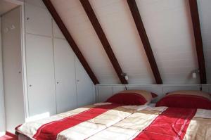 クックスハーフェンにあるFerienhaus Ringwall 80のベッドルーム1室(赤と白のベッド1台付)