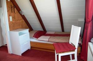 クックスハーフェンにあるFerienhaus Ringwall 80の小さなベッドルーム(ベッド1台、椅子付)
