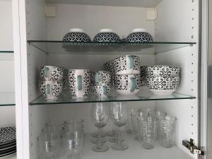 a cupboard filled with glasses and wine glasses at Gîte des hirondelles - Appartement de 75 m2 in Évette